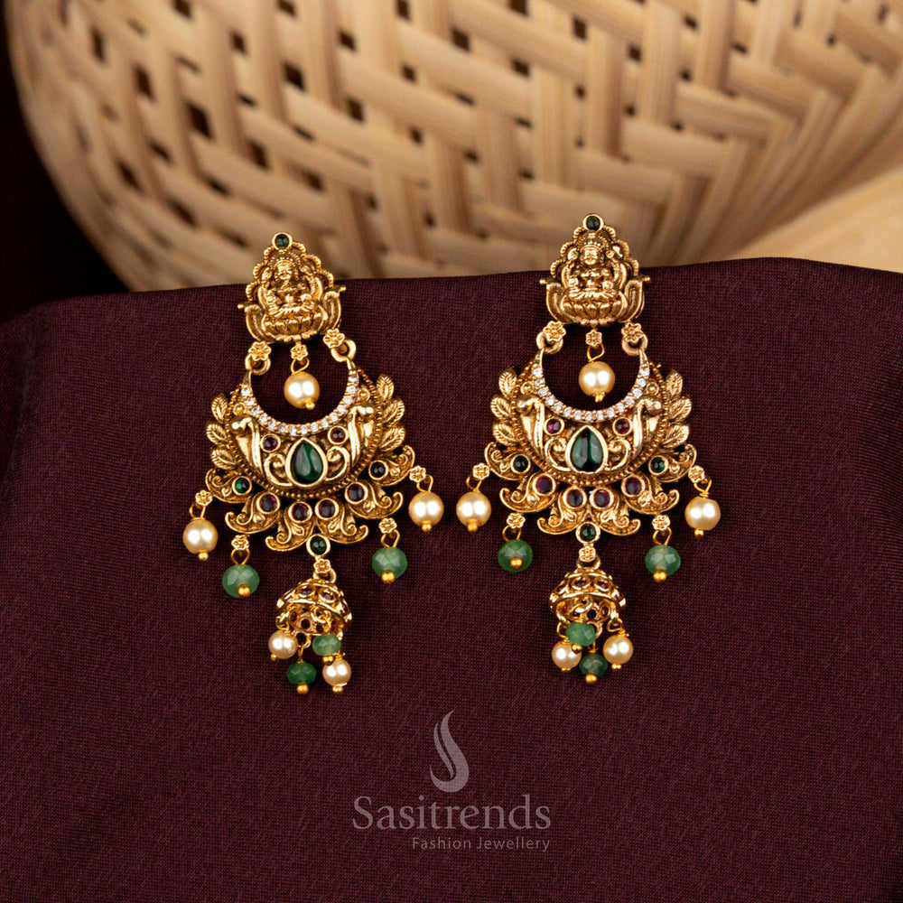 Opulent multicolor Lakshmi temple crescent earrings designed with illustrious floral carvings, sovereign matte gold artistry, resplendent AD brilliance, and aristocratic jhumka refinement – Sasitrends