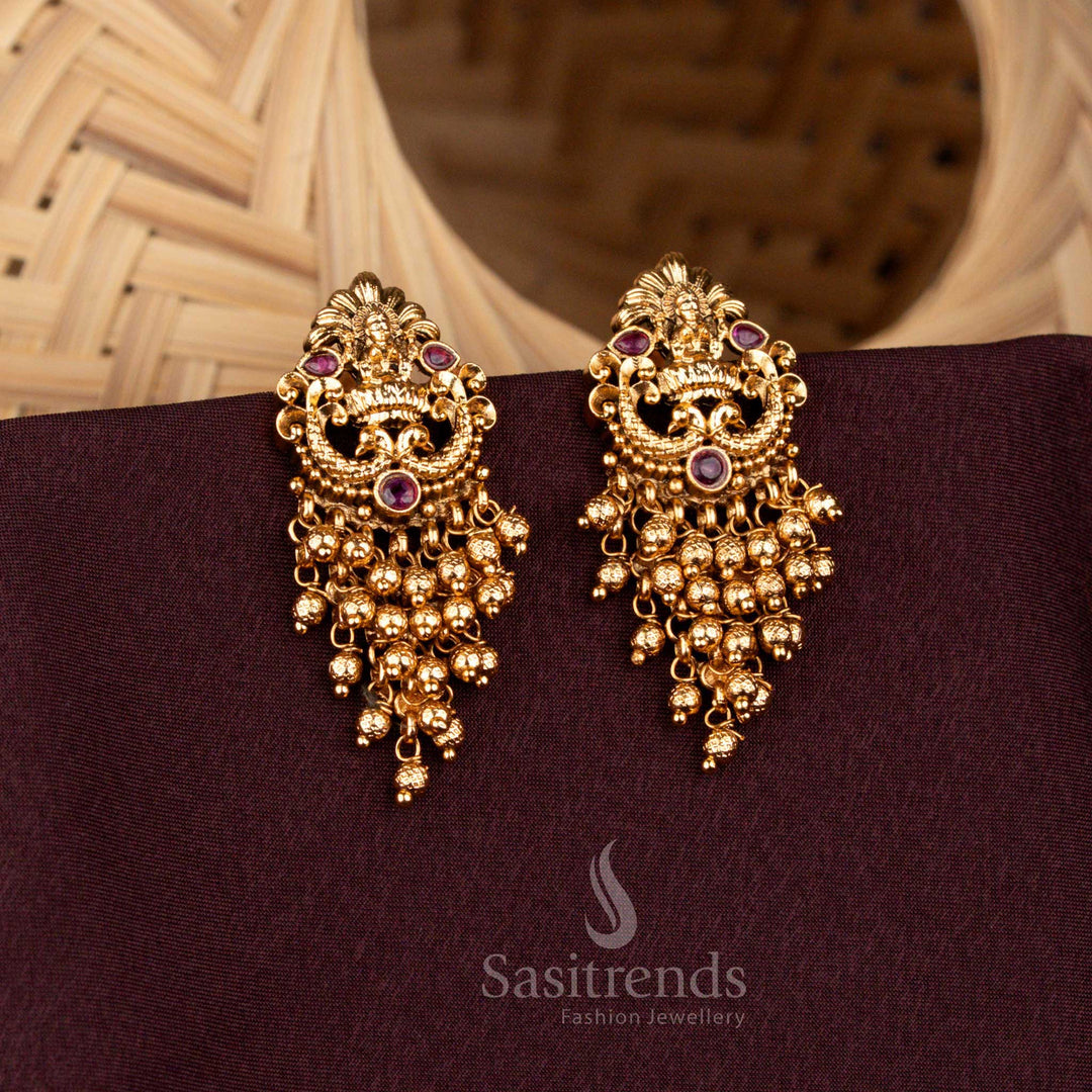 Elegant matte gold plated temple earrings showcasing Lakshmi and peacock artistry embellished with ruby stones and Gold beads – Sasitrends