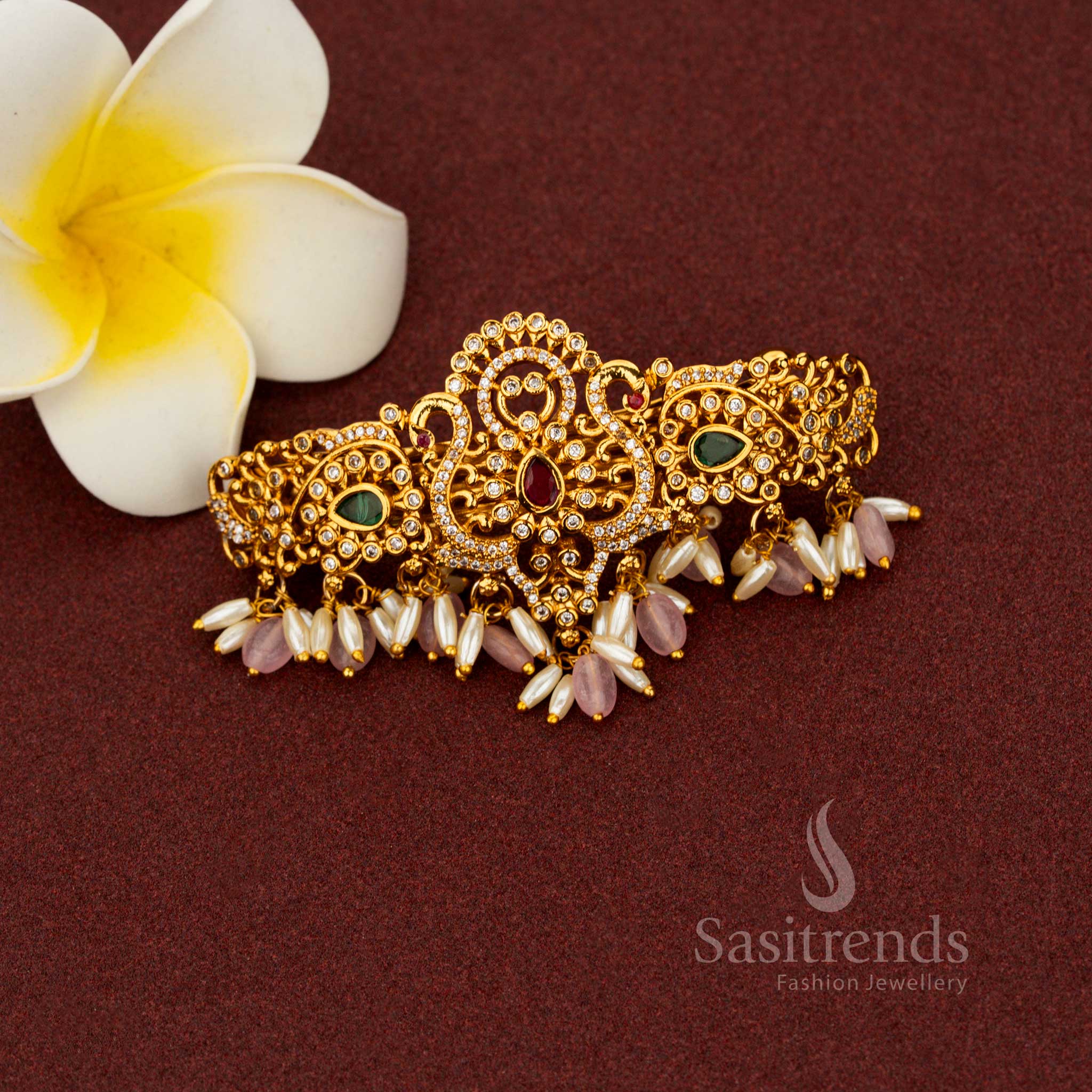 Seraphic pink matte gold hair clip enriched with teardrop floral detailing, luminous AD stones, ornate temple craftsmanship, and pearl highlights – Sasitrends
