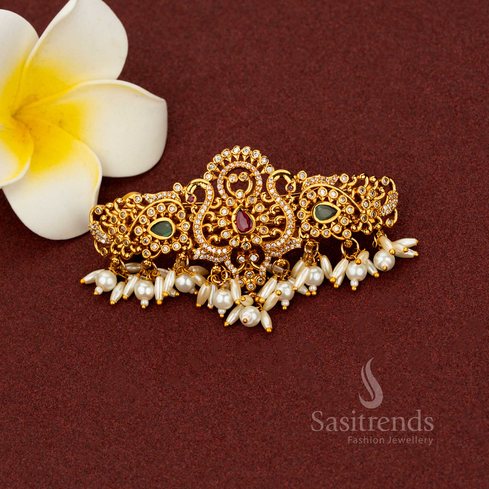 Exquisite white temple hair clip styled with divine matte gold artistry, ornate teardrop floral patterns, sparkling AD accents, and rice pearl drops – Sasitrends