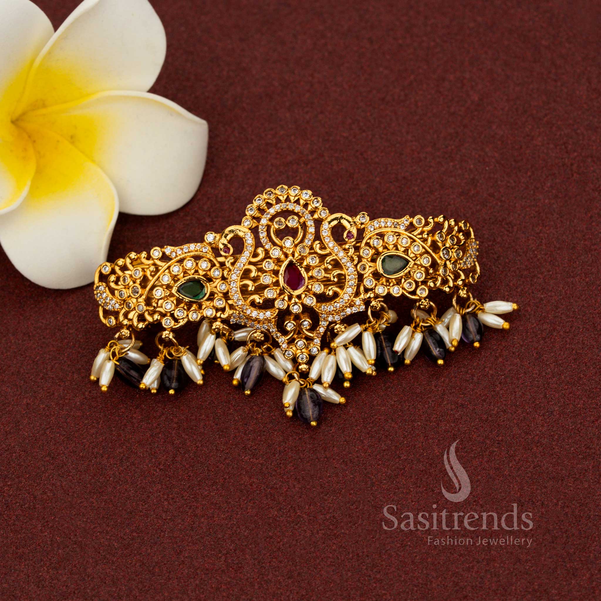 Glorious purple temple hair clip adorned with elegant matte gold finish, ornate teardrop floral motifs, radiant AD stones, and pearl accents – Sasitrends