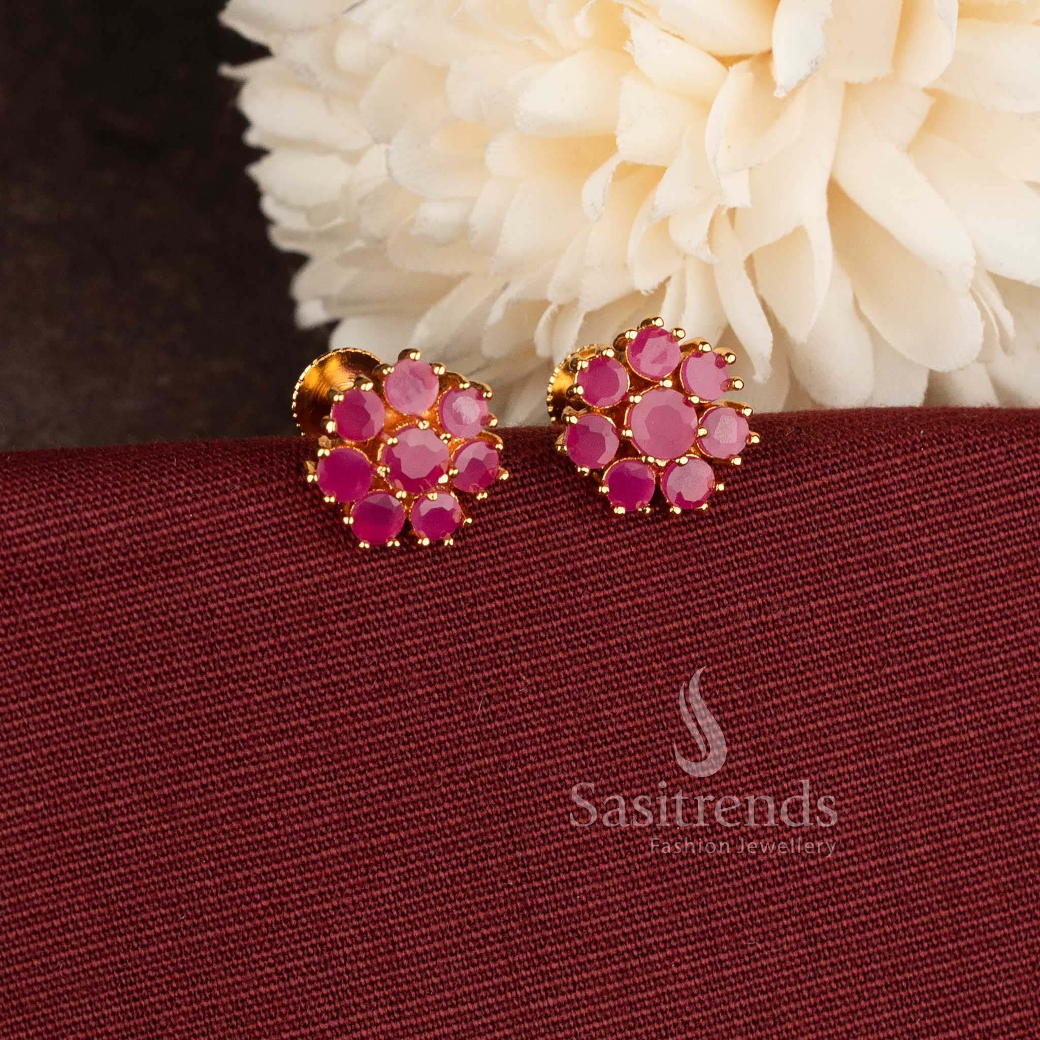 Trendy gold plated Ruby American Diamond stud earrings with floral pattern.