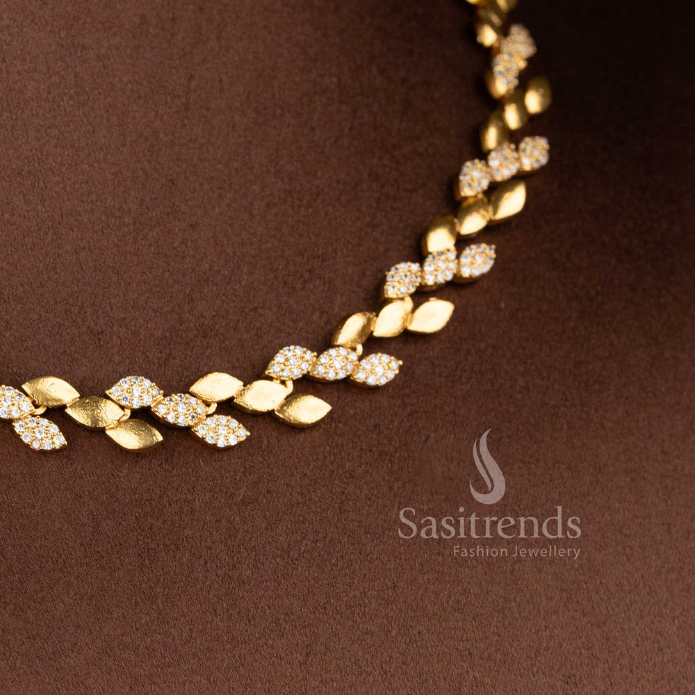 Close-up of the jewellery set showing the contrast between the smooth matte gold leaves and the shimmering stone-studded motifs - Sasitrends