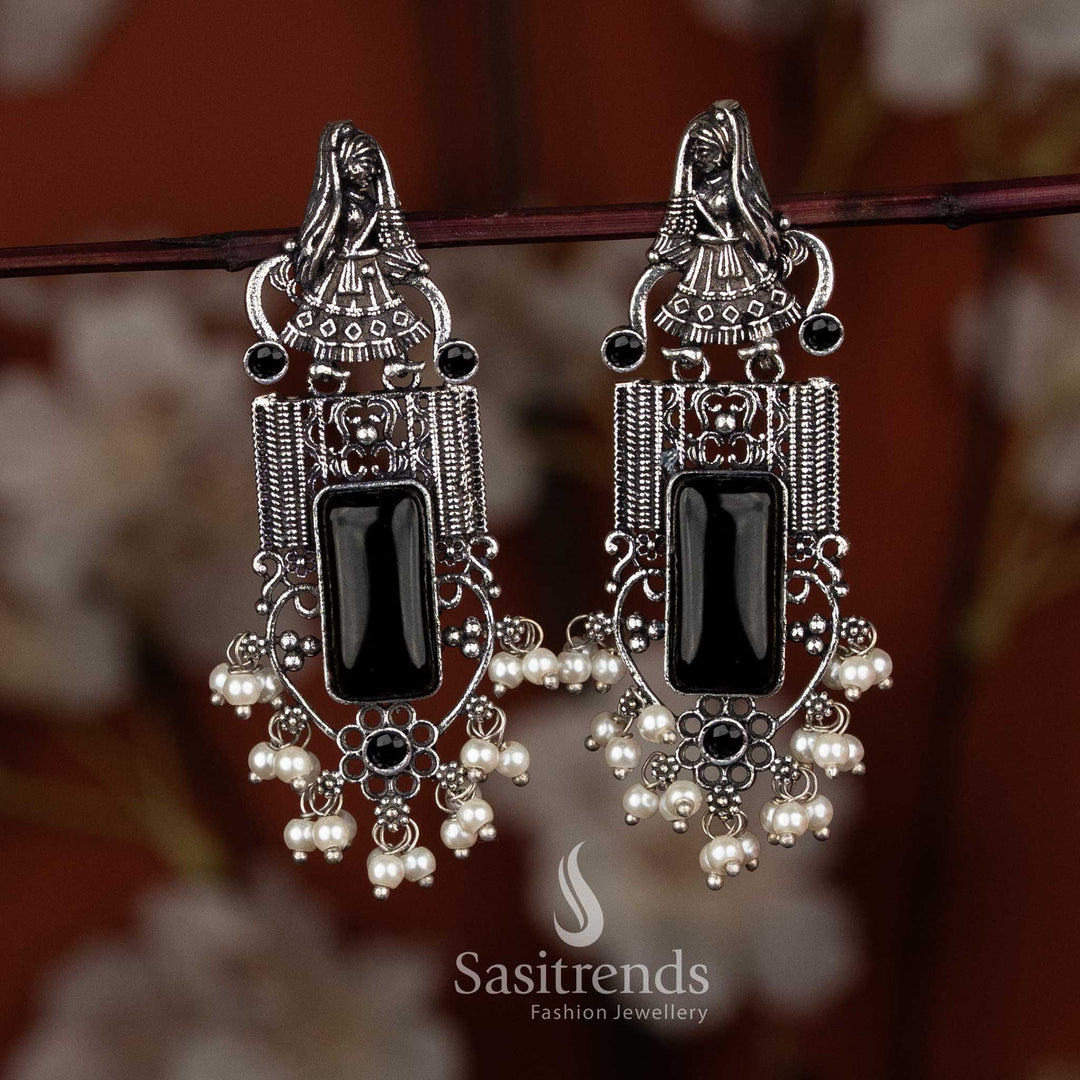 Sasitrends oxidised earrings featuring a dancer motif top, rectangular engraved centerpiece, intricate oxidised coiled wire design, and cascading pearl cluster detailing for ethnic heritage wear and festive styling.