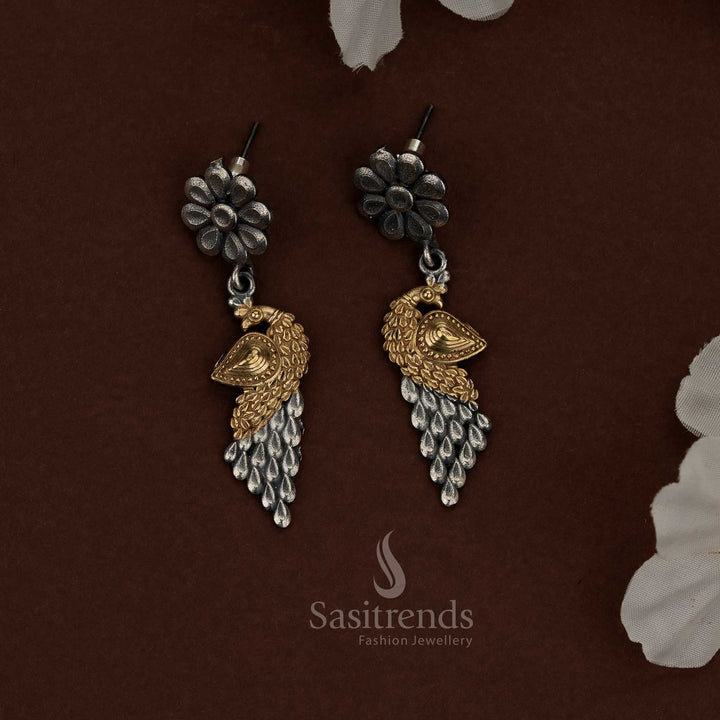 Sasitrends dual tone oxidised plated silver husli jewellery set designed with a strong crescent silhouette, intricate floral patterns engraved along the surface, a prominent layered peacock motif at the center, textured metal detailing, traditional thread closure, and matching earrings echoing floral and peacock-inspired ethnic design.
