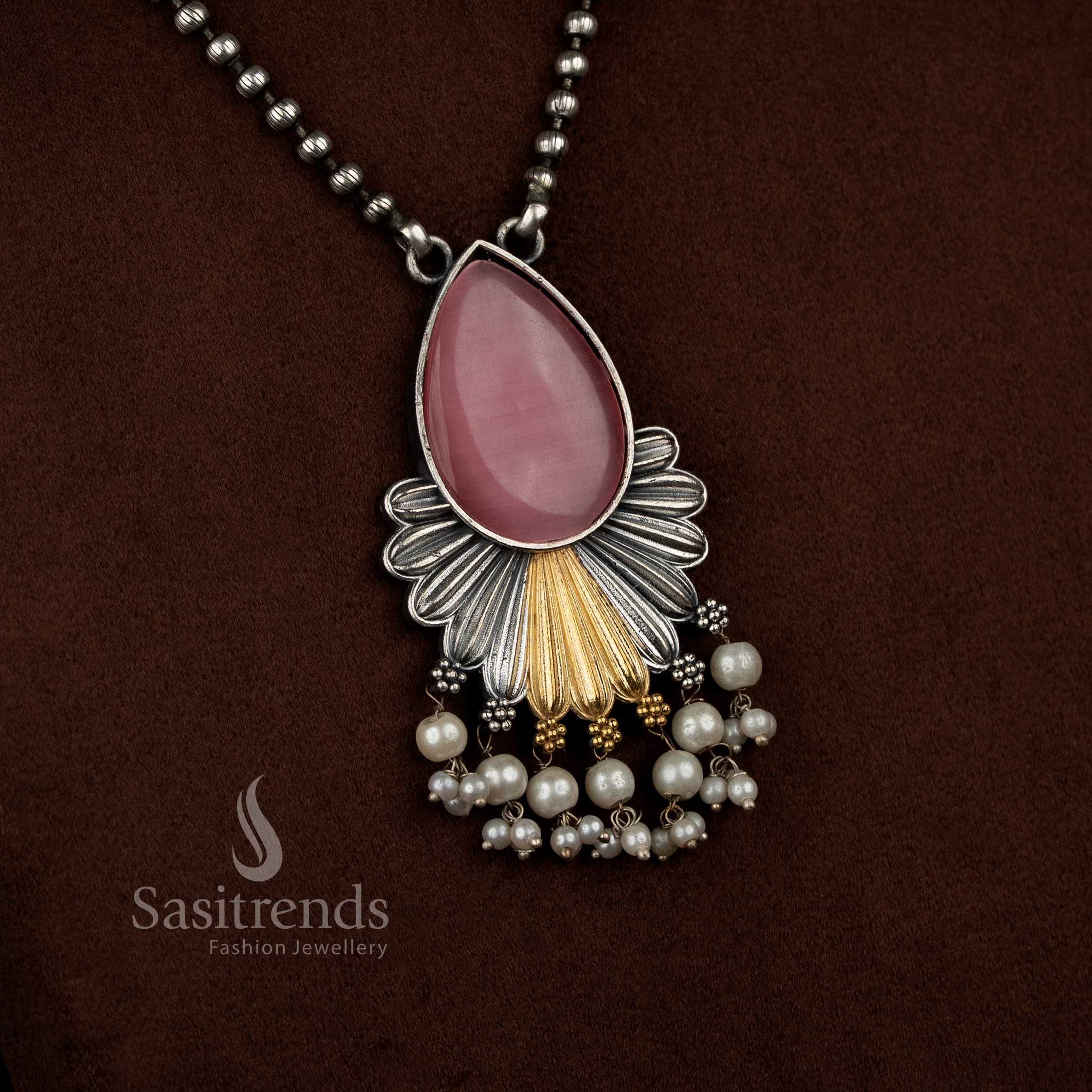 Antique oxidised 92.5 silver plated Monalisa stone necklace jewellery set in pink tone, crafted with a teardrop floral pendant design, layered silver structure, gold tone detailing, pearl bead danglers, oxidised bead chain, and matching floral motif earrings
