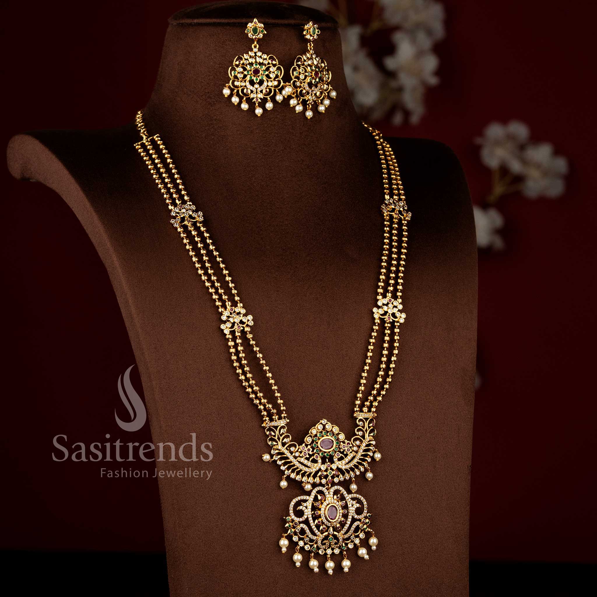 Sasitrends temple matte gold plated multi AD stone three layer long haram necklace jewellery set with peacock and floral pendant motifs