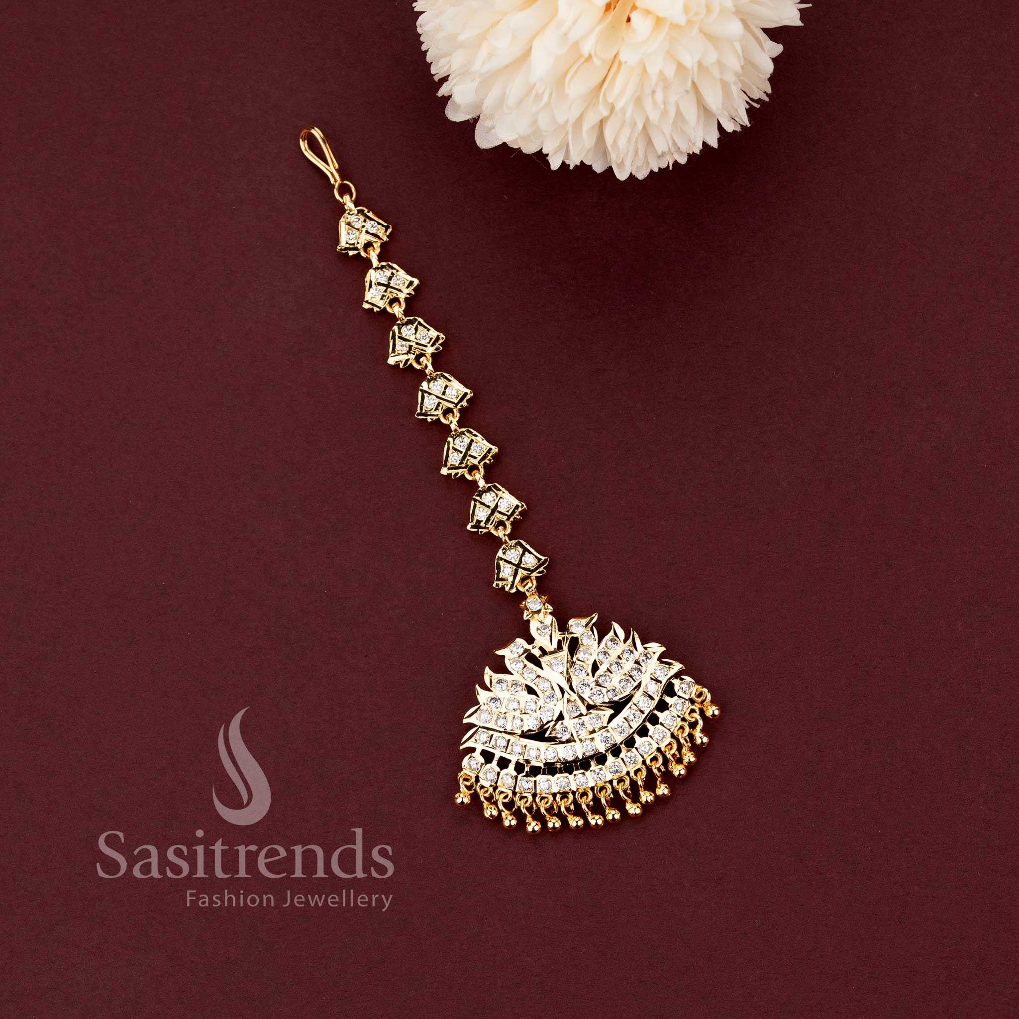 Grand Impon micro gold plated stone studded bell chain maang tikka with a traditional twin peacock semicircular AD pendant by Sasitrends.