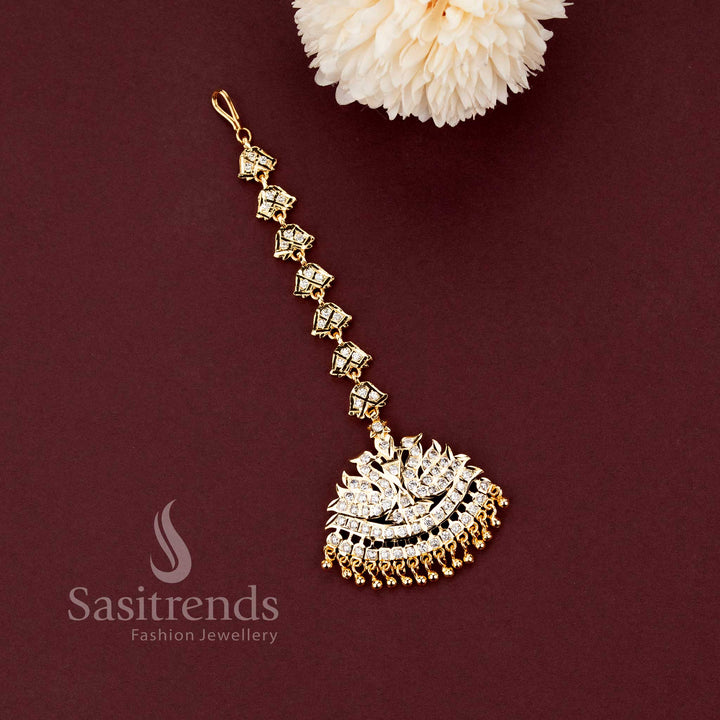 Grand Impon micro gold plated stone studded bell chain maang tikka with a traditional twin peacock semicircular AD pendant by Sasitrends.