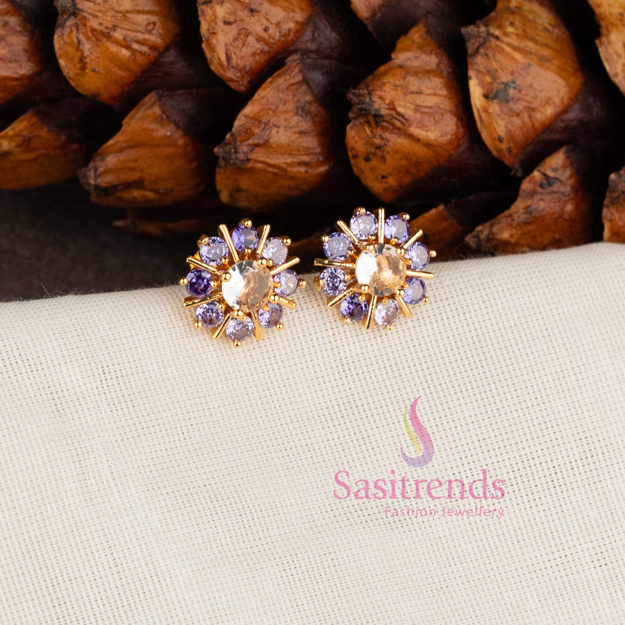 Trendy gold plated purple white American Diamond stud earrings with swirl floral pattern.