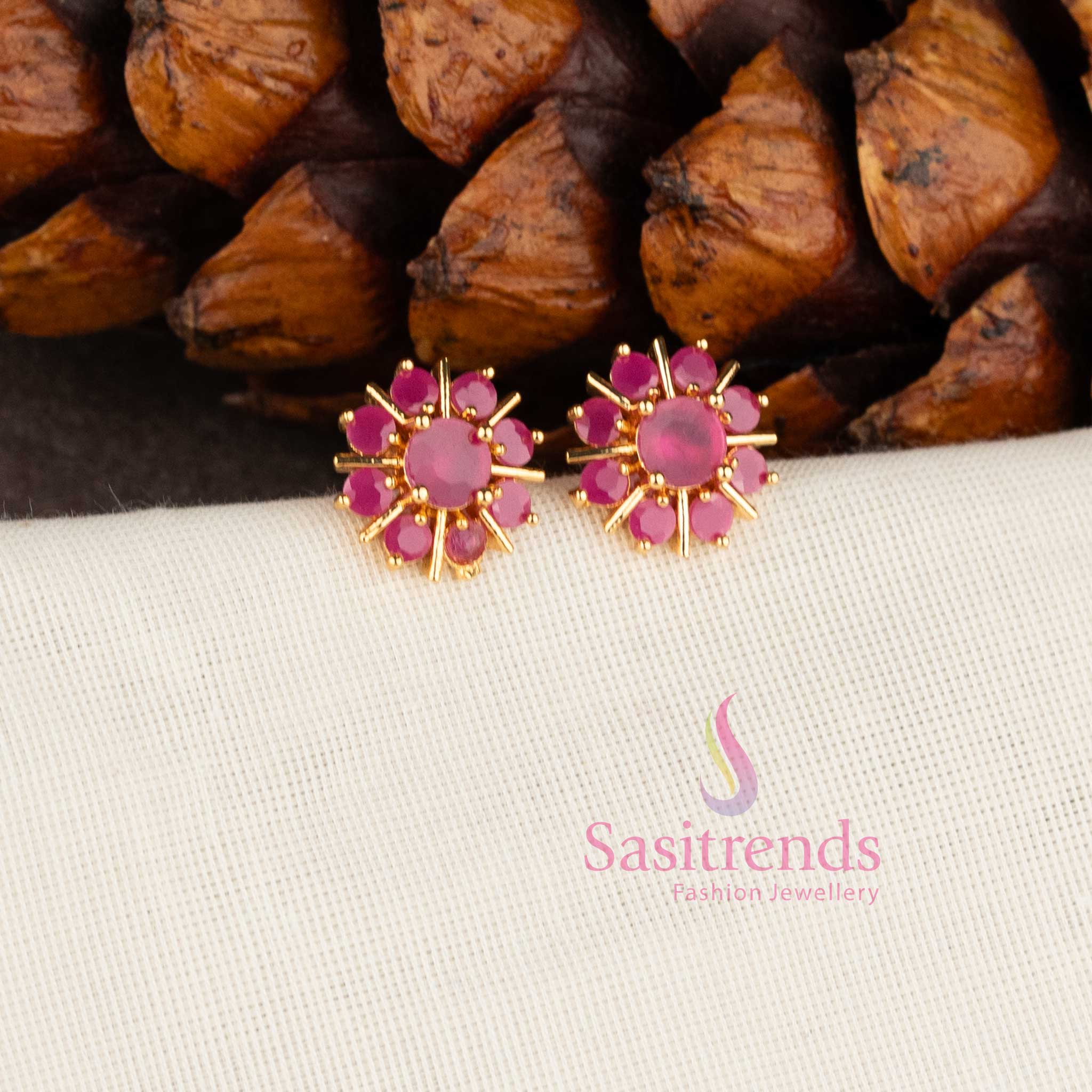 Trendy gold plated white American Diamond stud earrings with swirl floral pattern.