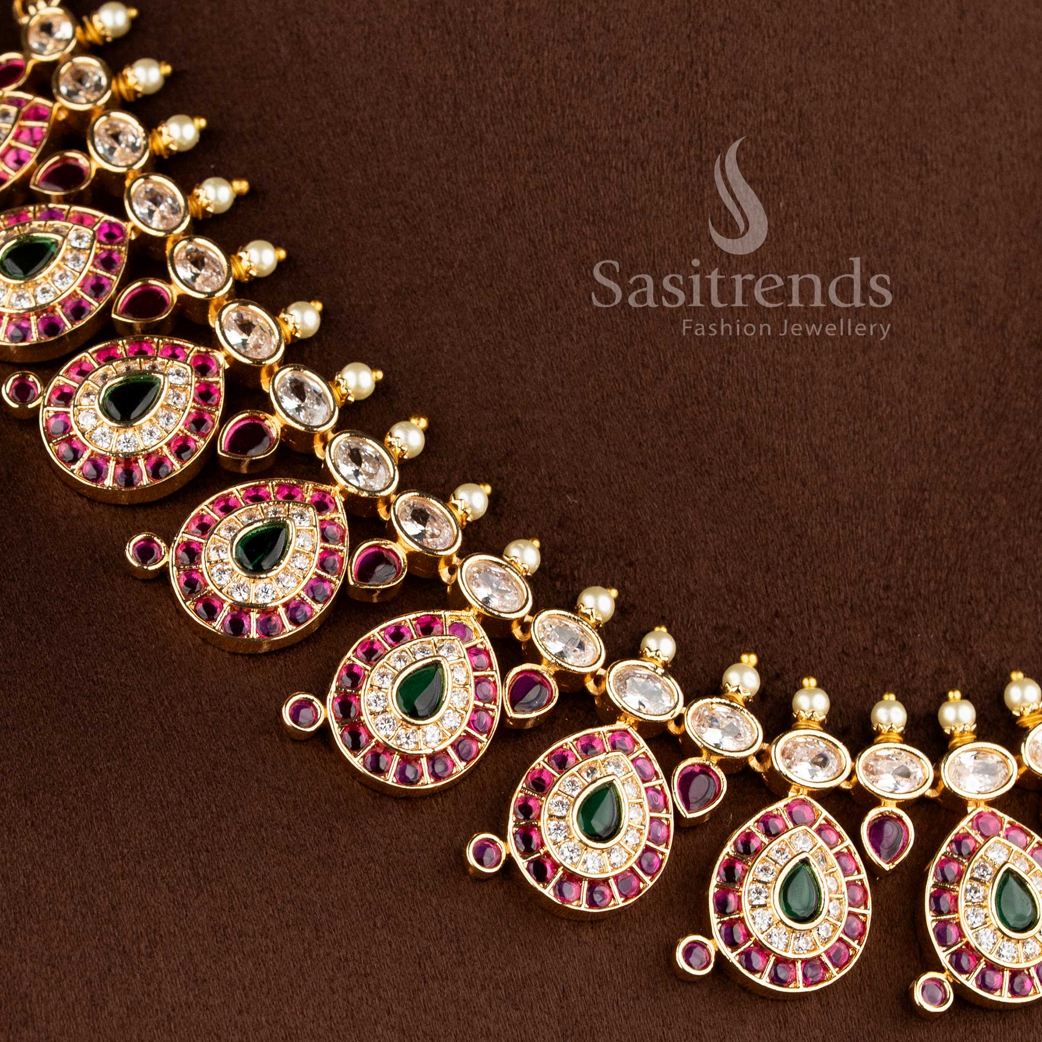 Close-up of an elegant wedding wear interlocking paisley leaf necklace layout with pink stones and pearl bead drops.