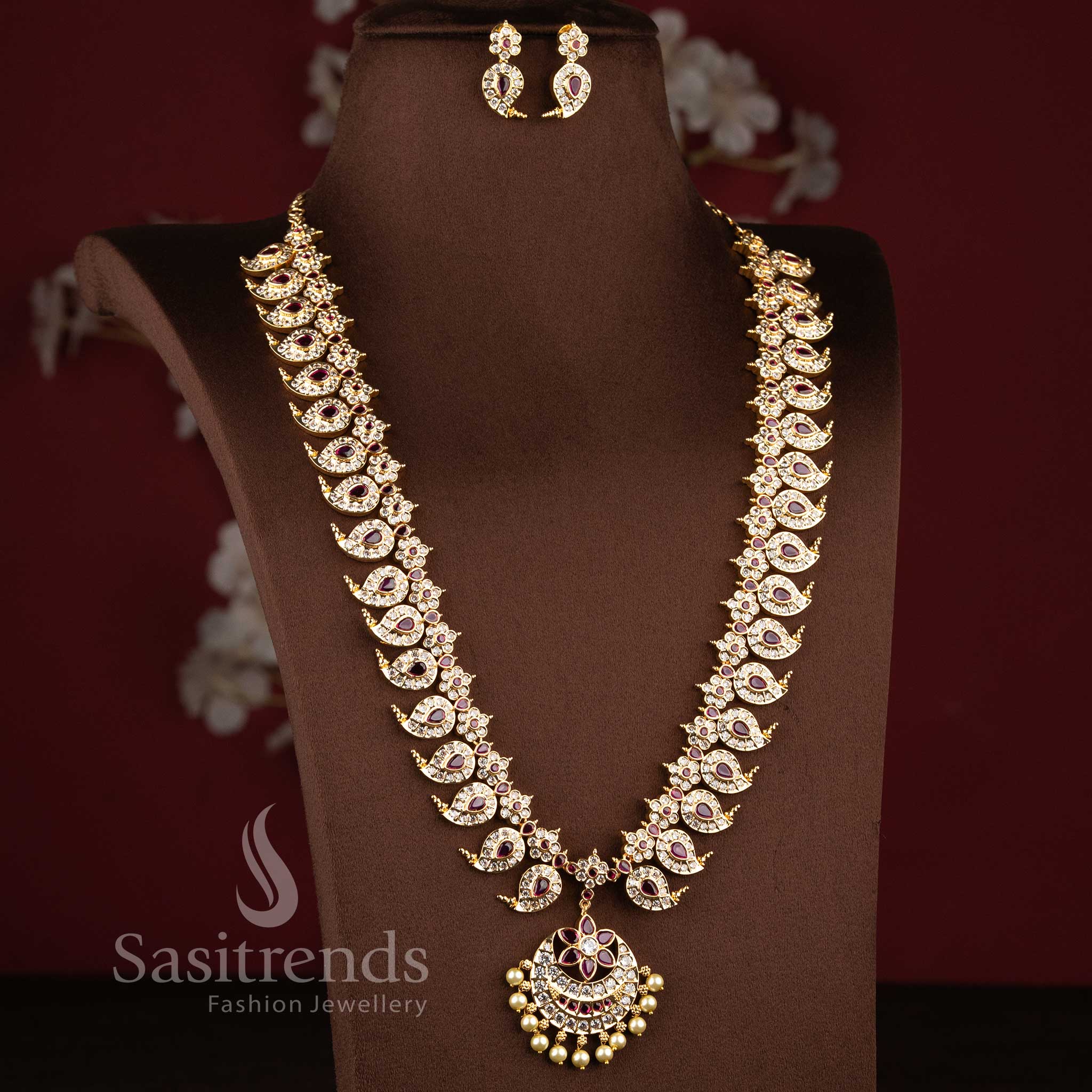 Real gold look wedding wear long necklace set showcasing a pearl drop floral blossom centerpiece.