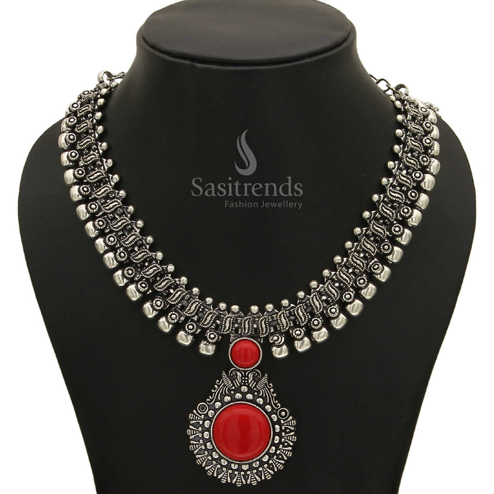 Dazzling Haarini oxidised silver necklace adorned with a deep crimson ember red gemstone pendant, offering a warm and captivating glow from Sasitrends