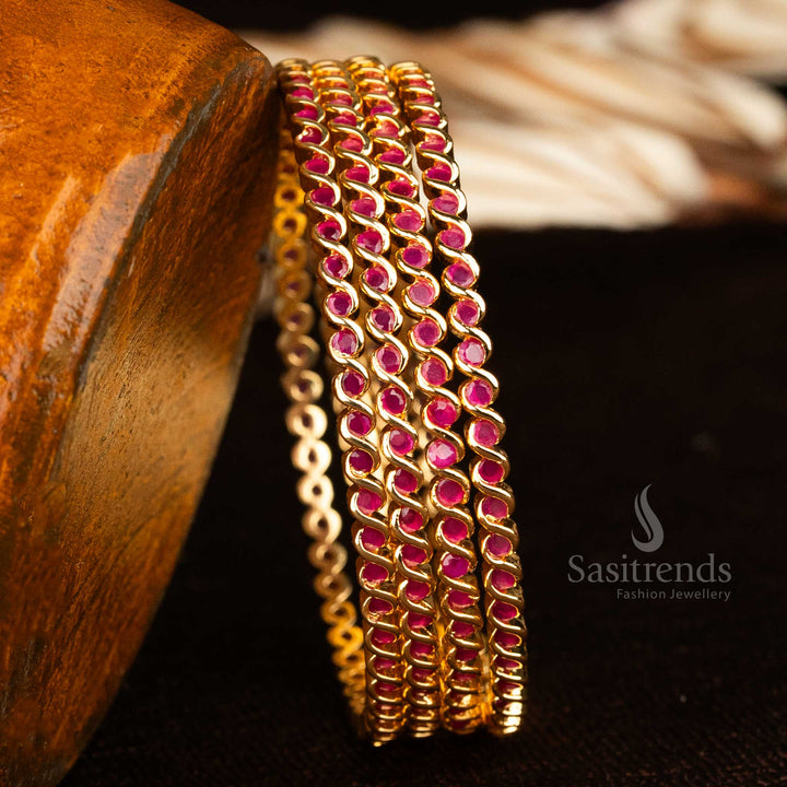Elegant spiral pattern bangles in micro gold finish with ruby American diamond stones and traditional temple charm for bridal jewellery styling – sasitrends