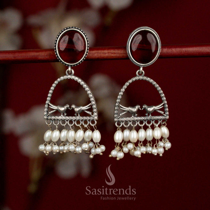 Deep toned oxidised 92.5 silver earrings featuring maroon Monalisa stone, curved dual bird arch design and pearl detailing for expressive ethnic looks - Sasitrends