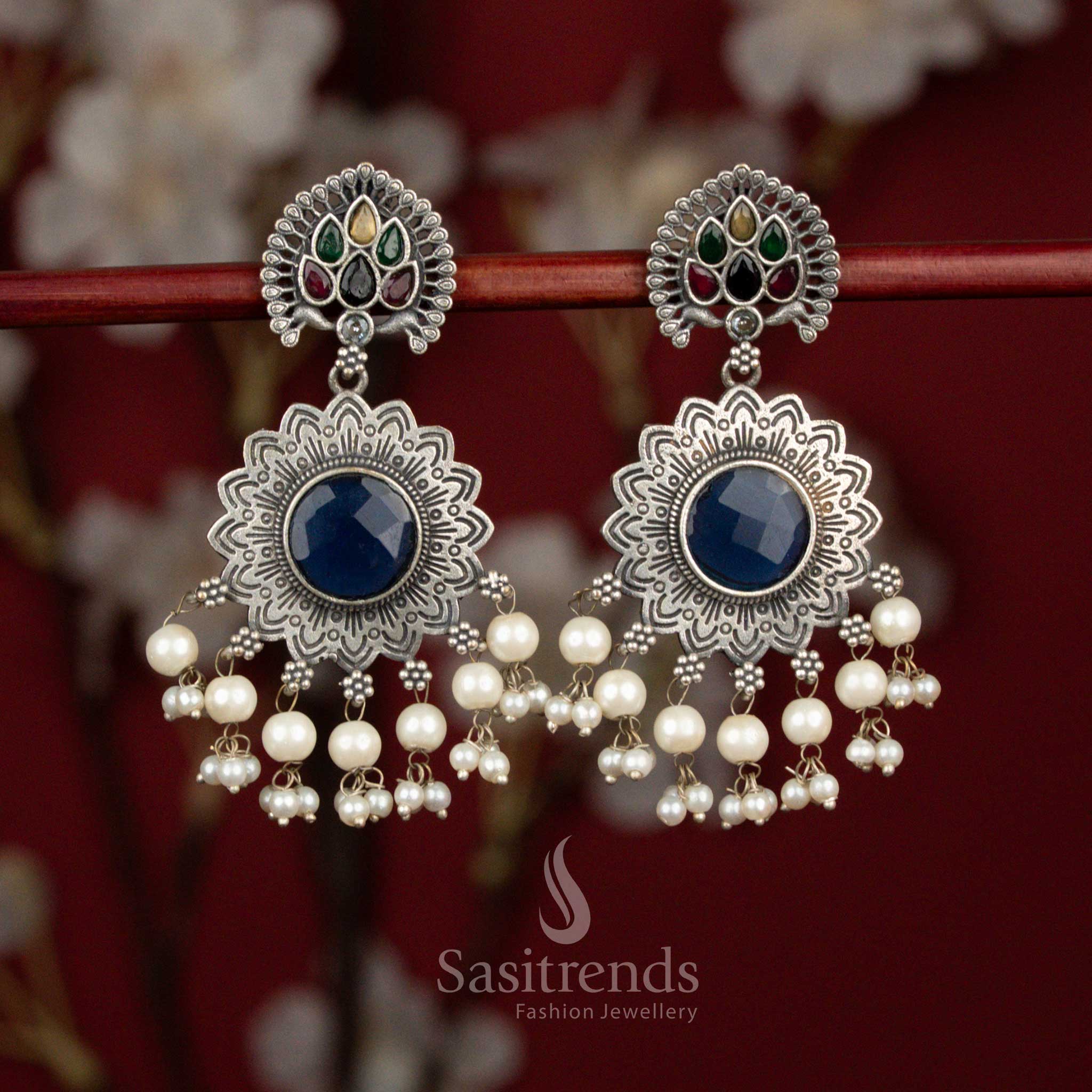 Antique oxidised silver earrings designed with multicolour Monalisa stones, peacock feather sun motif and pearl accents for expressive party wear - Sasitrends