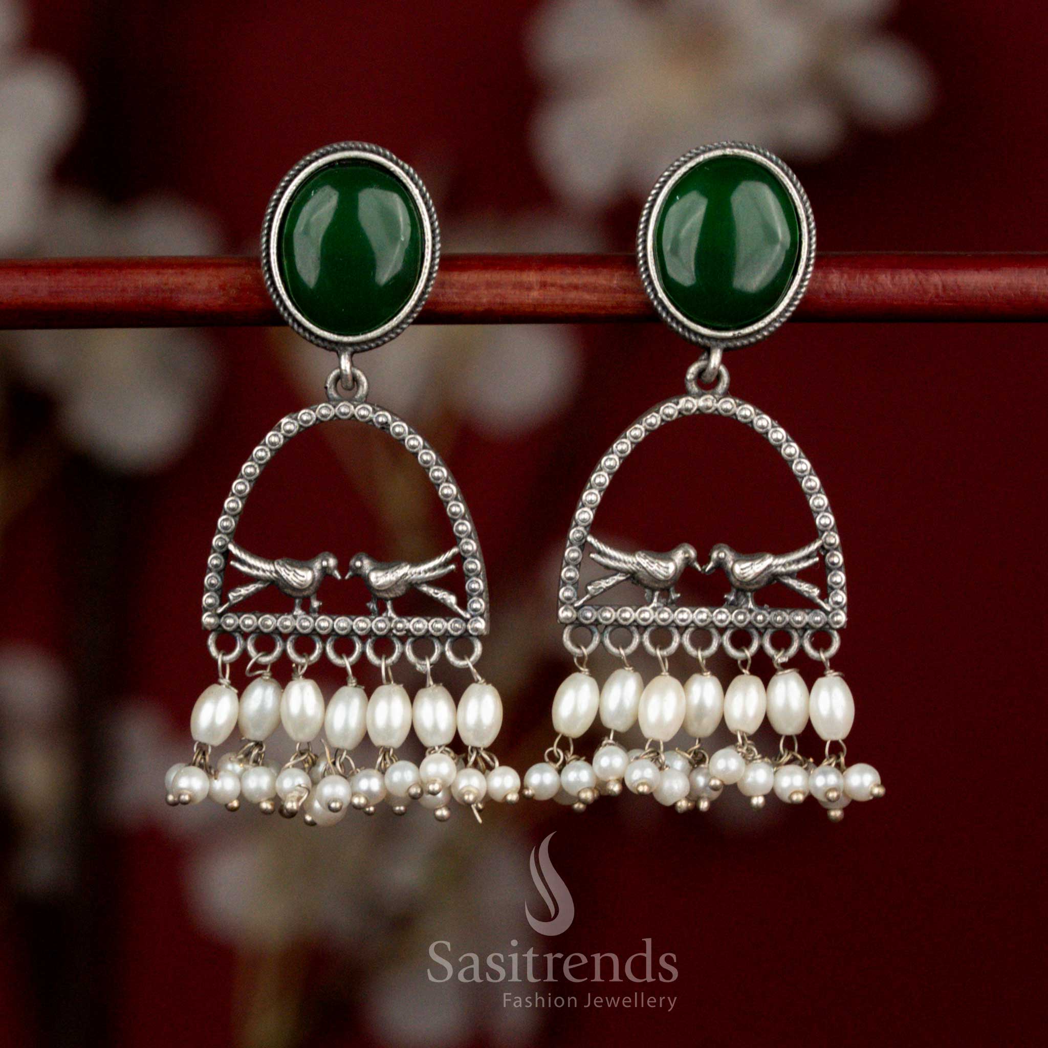 Earth inspired oxidised 92.5 silver earrings with green Monalisa stone, artistic dual bird arch motif and pearl drops for heritage influenced styling - Sasitrends