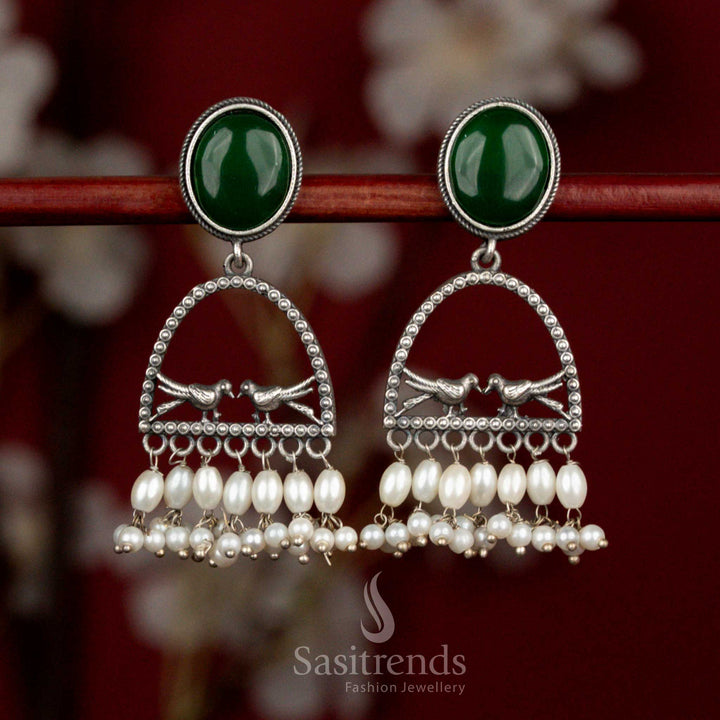Earth inspired oxidised 92.5 silver earrings with green Monalisa stone, artistic dual bird arch motif and pearl drops for heritage influenced styling - Sasitrends