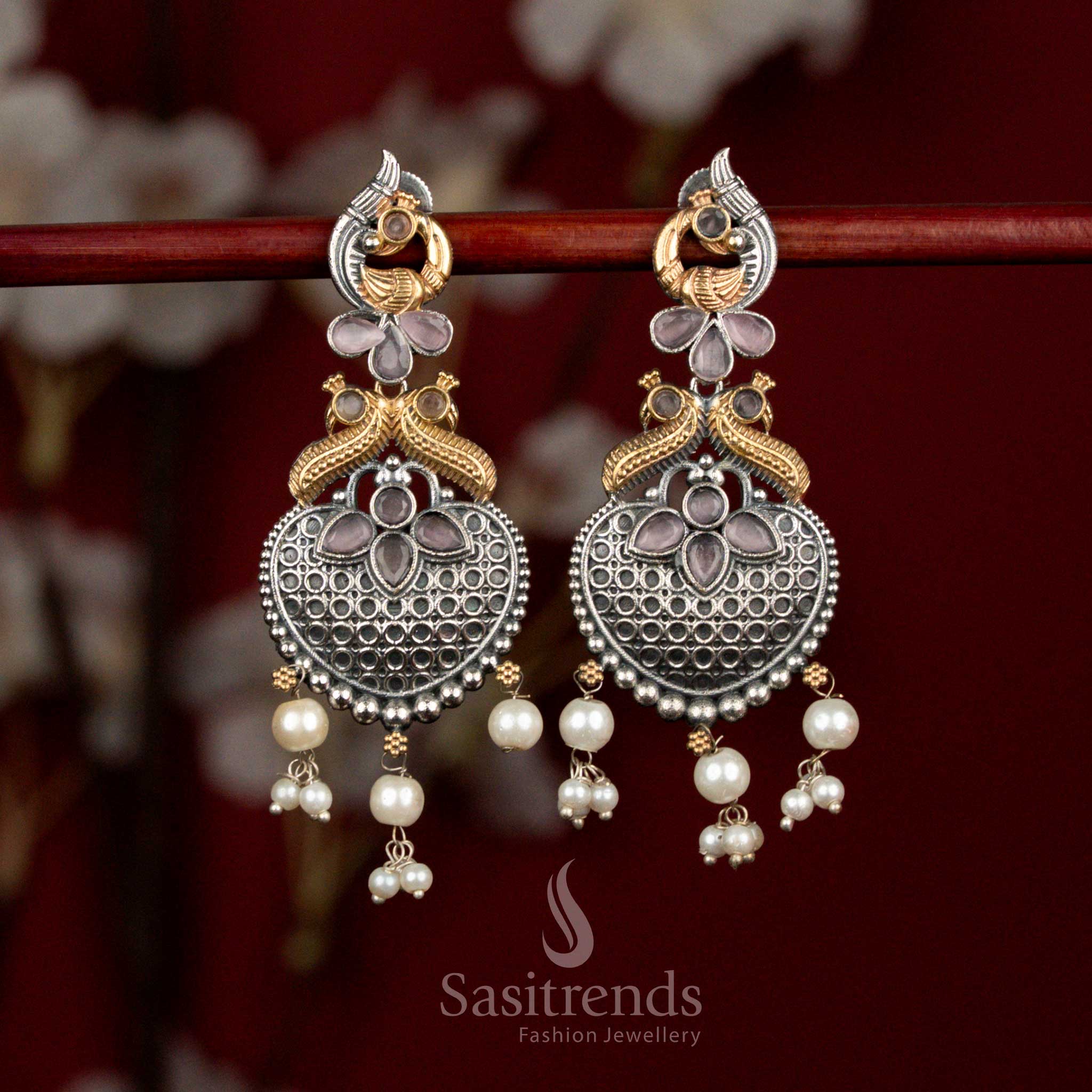 Artistic oxidised silver earrings featuring pink Monalisa stones, sculpted peacock heart design and delicate pearl cluster drops for graceful festive wear - Sasitrends
