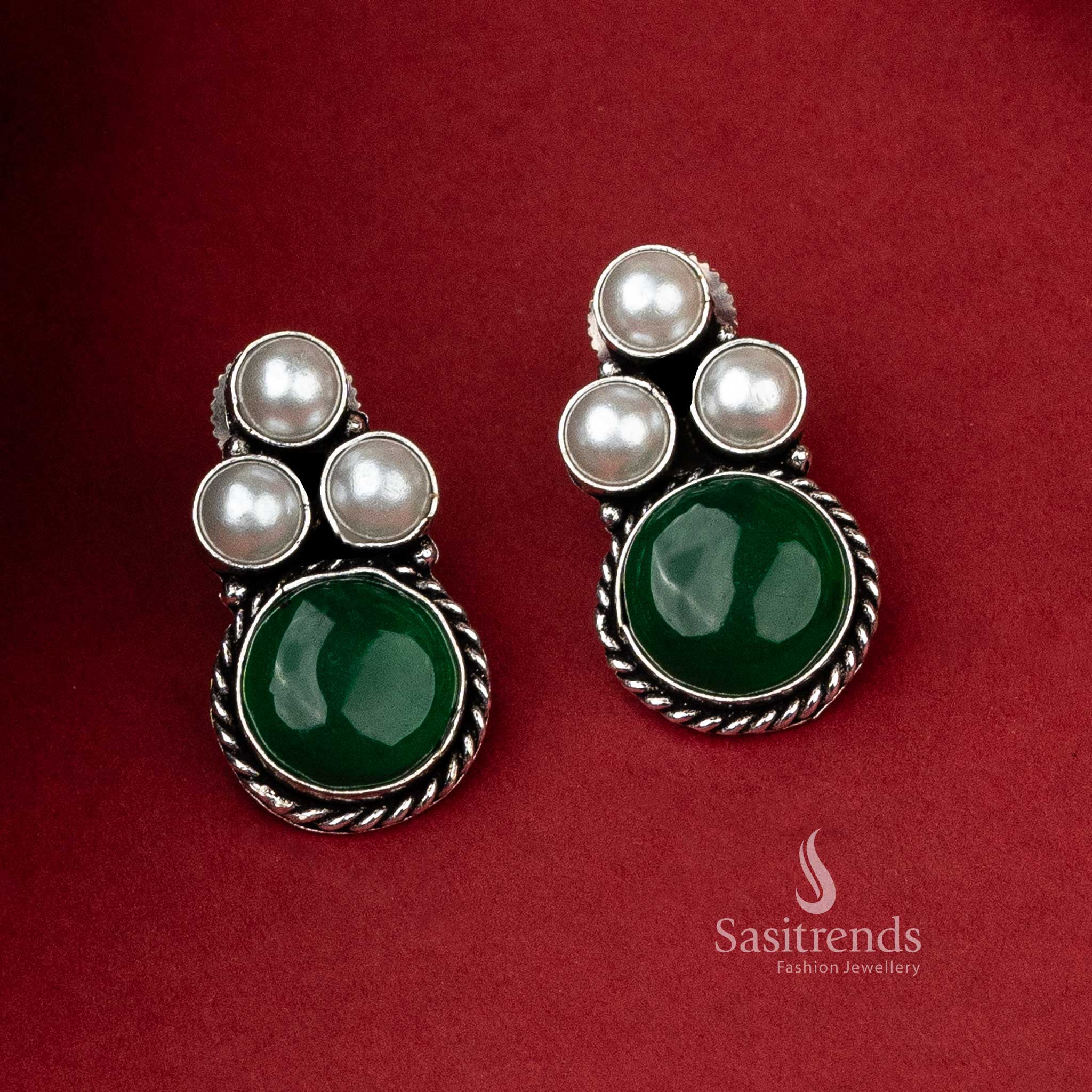 Oxidised silver earrings adorned with three pearls and a deep green monalisa stone, perfect for an elegant outfit.