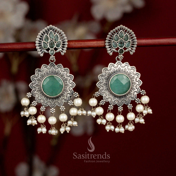 Antique oxidised silver plated earrings designed with mint Monalisa stones, sunburst peacock feather floral motif and pearl detailing for refined party looks - Sasitrends