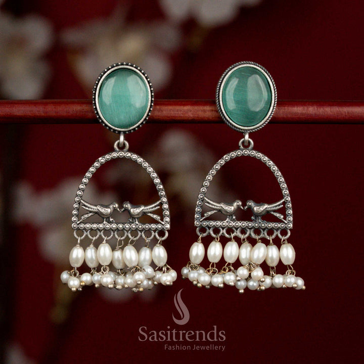 Antique oxidised 92.5 silver earrings designed with mint oval Monalisa stone, spherical arch dual bird motif and rice pearl drops for refined cultural looks - Sasitrends