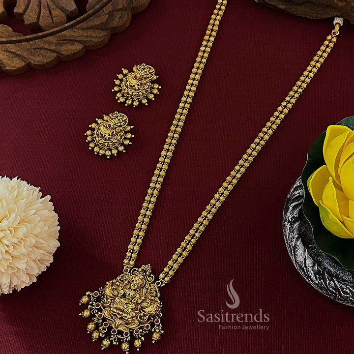 Elegant ruby matte gold plated temple bridal long jewellery set with Lakshmi pendant and ornate jhumkas, crafted for timeless beauty and cultural sophistication – Sasitrends