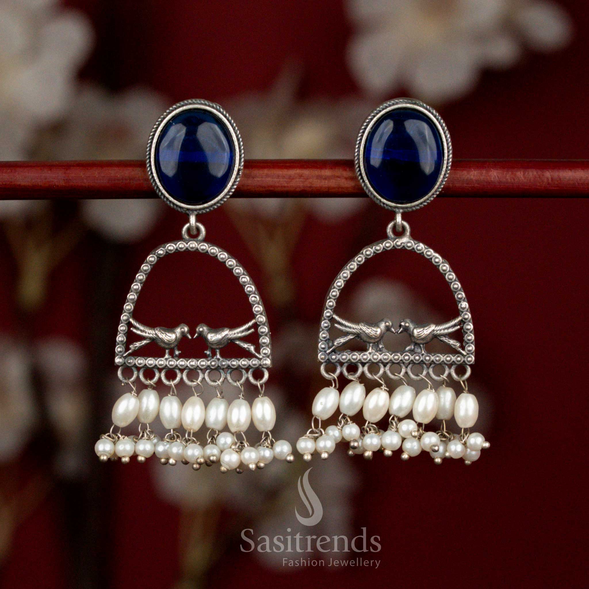 Antique oxidised silver earrings featuring blue oval Monalisa stone, spherical arch dual bird form and rice pearl hangings for graceful cultural styling - Sasitrends