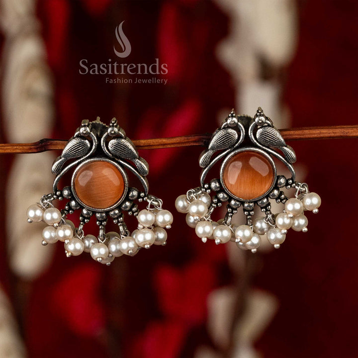 Oxidised earrings in a peacock design with burgundy stones and a trim of pearls