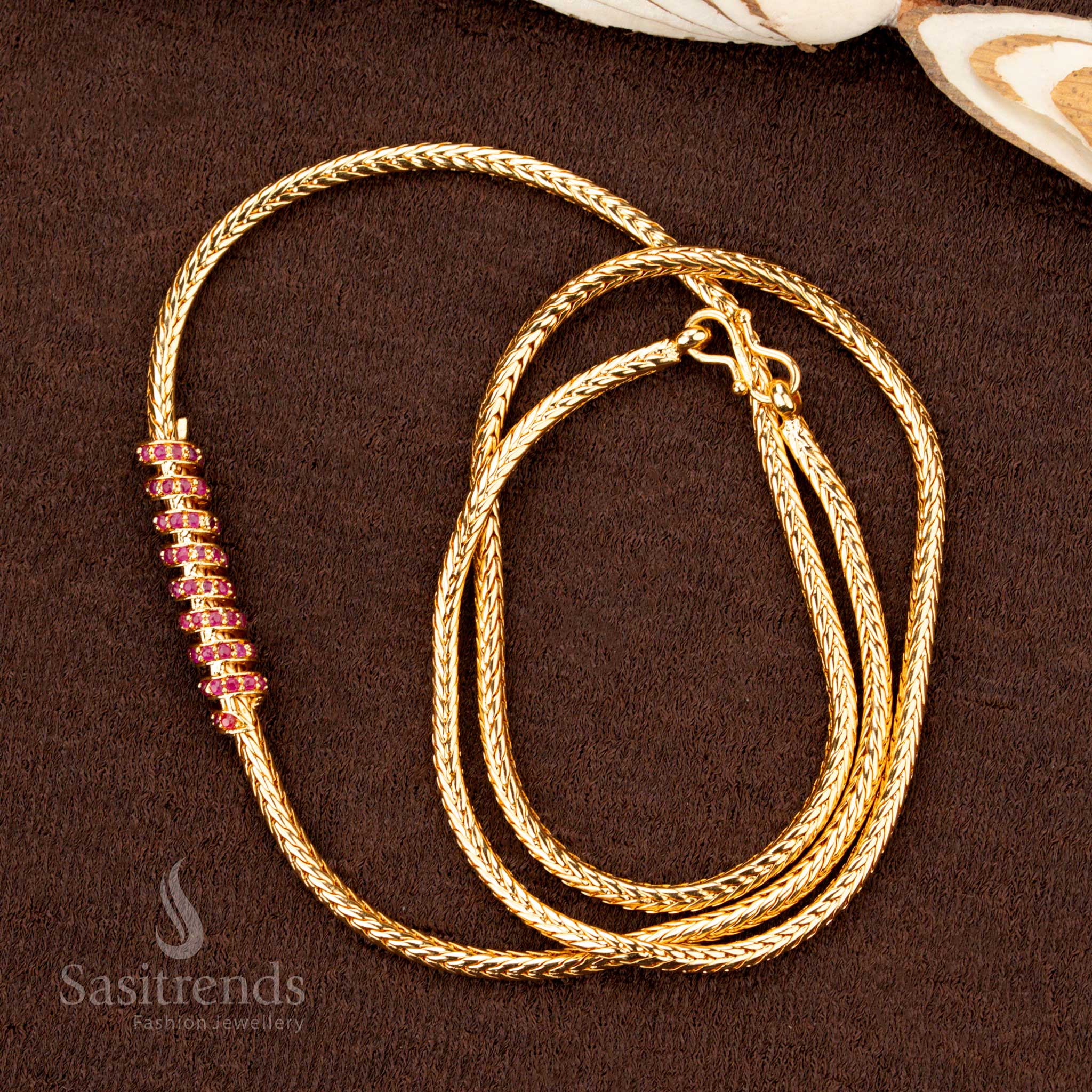 A premium one-gram gold plated spiral spring design mugappu chain featuring glittering ruby-crimson AD stones, an ethnic jewellery masterpiece for a graceful and festive look - Sasitrends