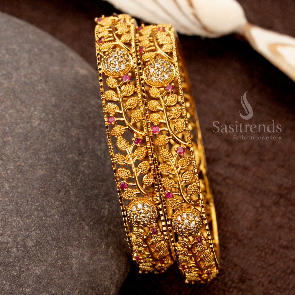 Grand matte gold bangles studded with white and ruby AD stones in an intricate leaf pattern, perfect for weddings and celebrations - Sasitrends