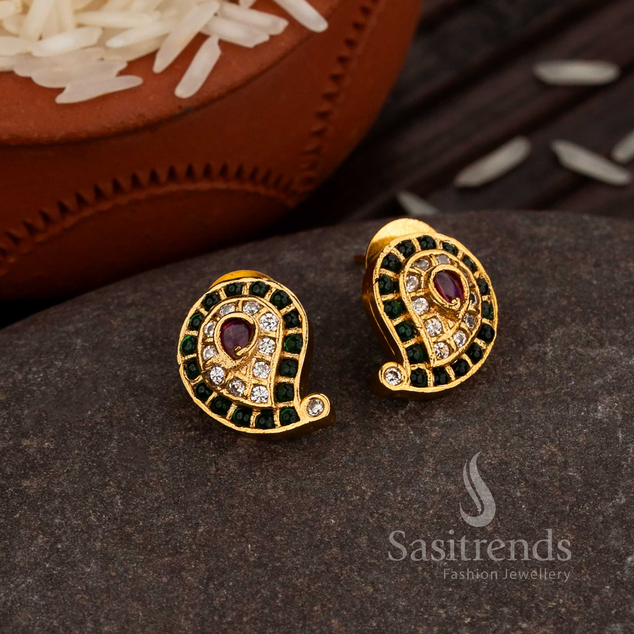 Classic Matte Gold Paisley Stud Earrings Enhanced With Green-Ruby American Diamond Embellishments, A Cultural Statement Jewellery Piece For Grand Occasions – Sasitrends