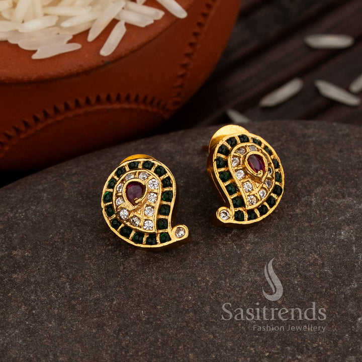Classic Matte Gold Paisley Stud Earrings Enhanced With Green-Ruby American Diamond Embellishments, A Cultural Statement Jewellery Piece For Grand Occasions – Sasitrends