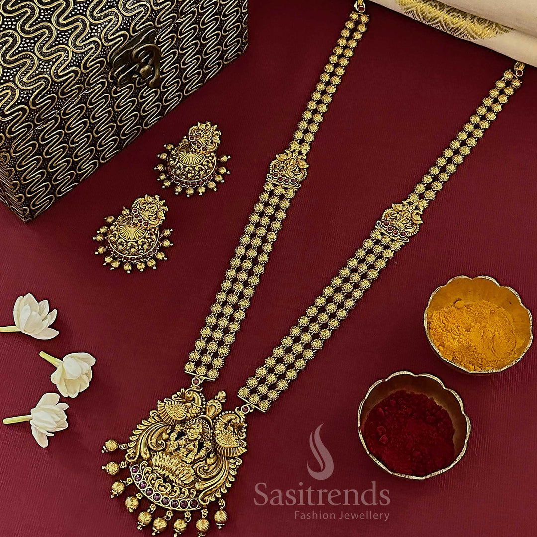 Ruby triple-layered Lakshmi peacock necklace set with jhumkas, crafted in matte gold temple jewellery style with heritage vibes and ceremonial elegance by Sasitrends