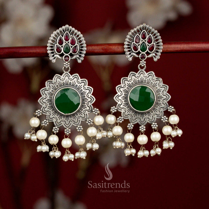Antique oxidised silver earrings accented with ruby and green Monalisa stones, layered peacock sun floral motif and pearl elements for vibrant styling - Sasitrends