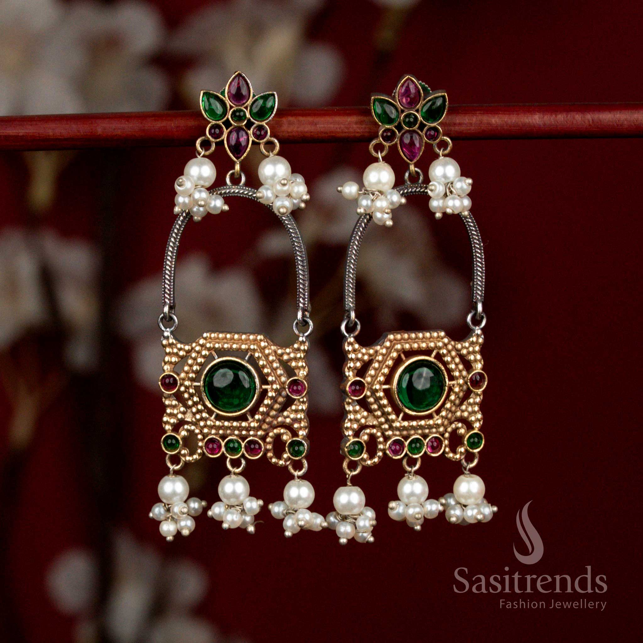 Artistic oxidised silver earrings featuring ruby-green Monalisa stones, layered floral arch motifs and delicate pearl cluster drops for festive ethnic occasions - Sasitrends