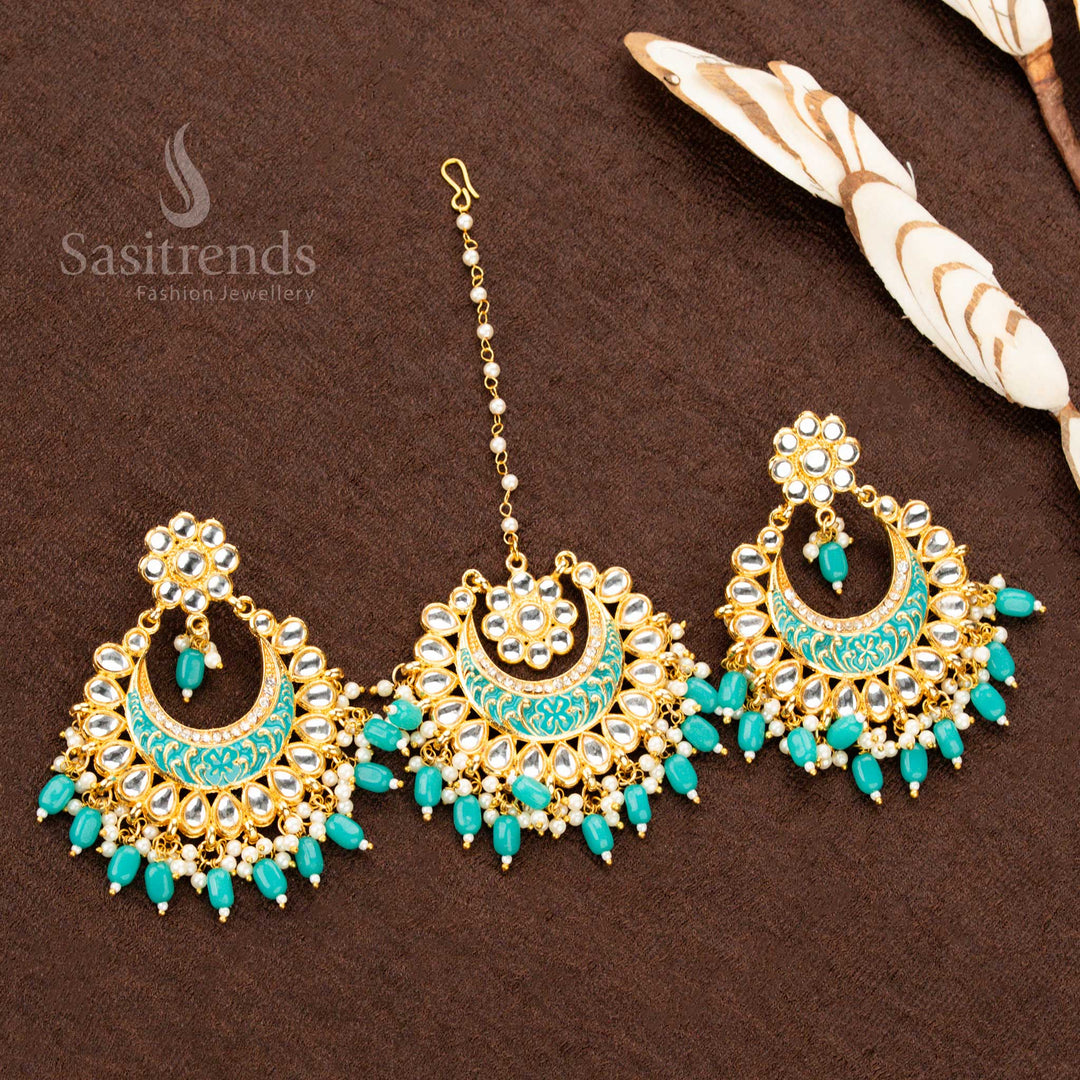 Handcrafted gold plated tikka and earrings set, featuring soft sky blue floral paintwork, ornate stone details, and pearl bead highlights, crafted for a refined ethnic jewellery statement - Sasitrends