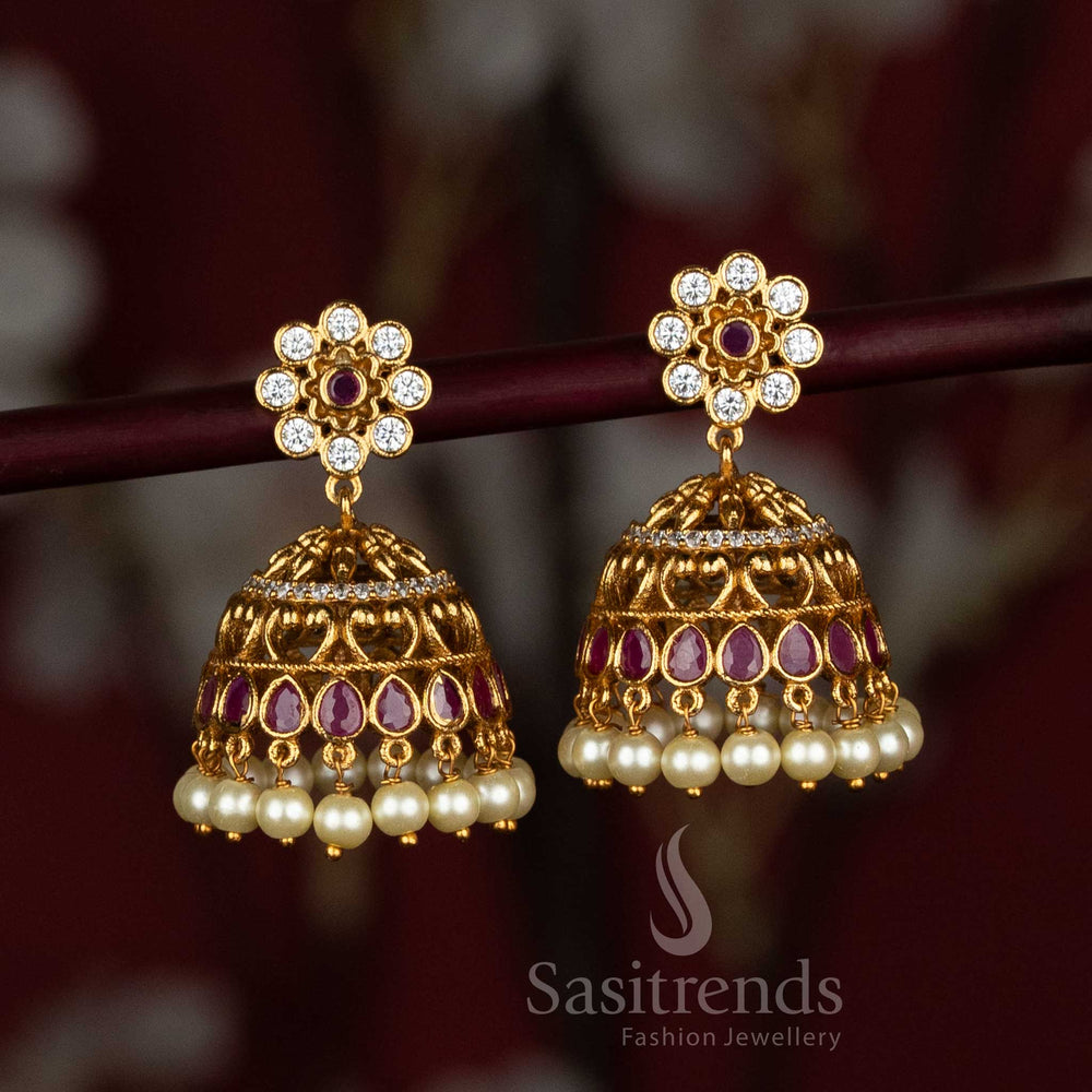 Traditional temple-style matte gold plated AD jhumka earrings, beautifully embellished with pearl hangings and intricate motifs – a graceful choice for festive jewellery wear by Sasitrends

