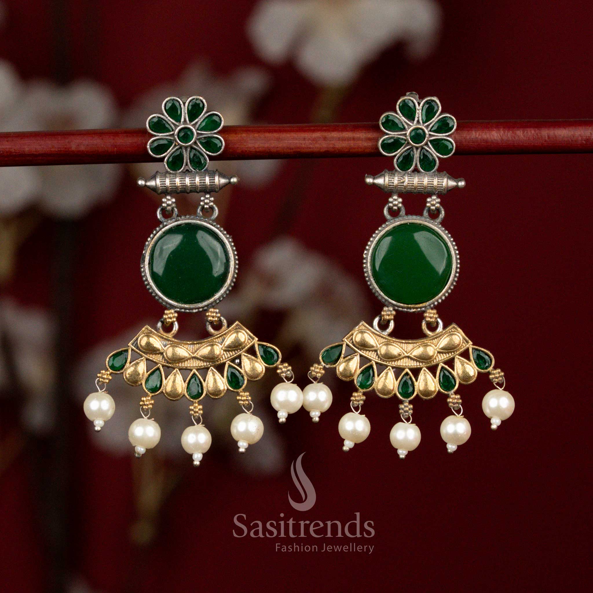 Antique dual tone oxidised silver earrings featuring green Monalisa stones, sculpted crescent flower design and delicate pearl accents for sophisticated party wear - Sasitrends