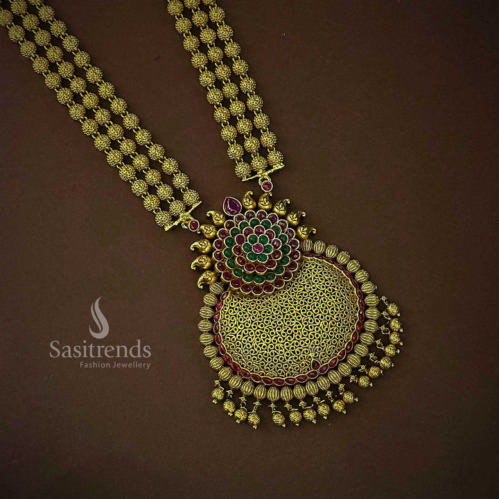 Grand traditional bridal temple jewellery set in matte gold featuring an elaborate three-layered bead floral pendant and handcrafted jhumkas, accented with rich ruby-green stones for timeless bridal splendor – Sasitrends