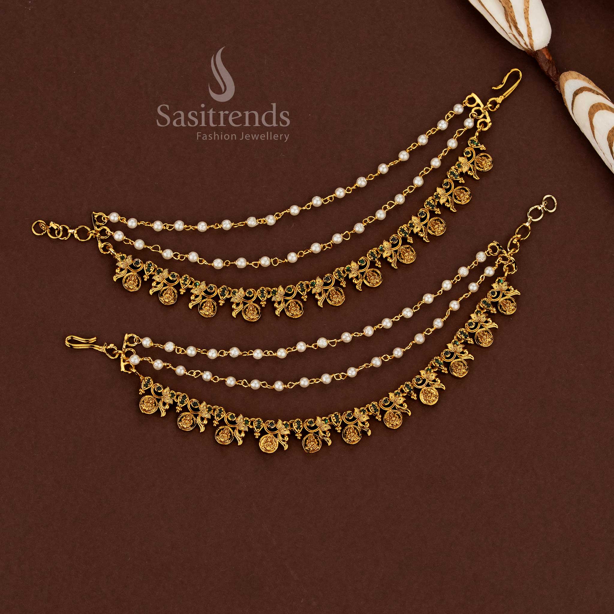 Sacred Lakshmi motif temple matte gold plated American diamond matil ear chains adorned with lush green stones and pearl detailing for wedding ceremonies - Sasitrends