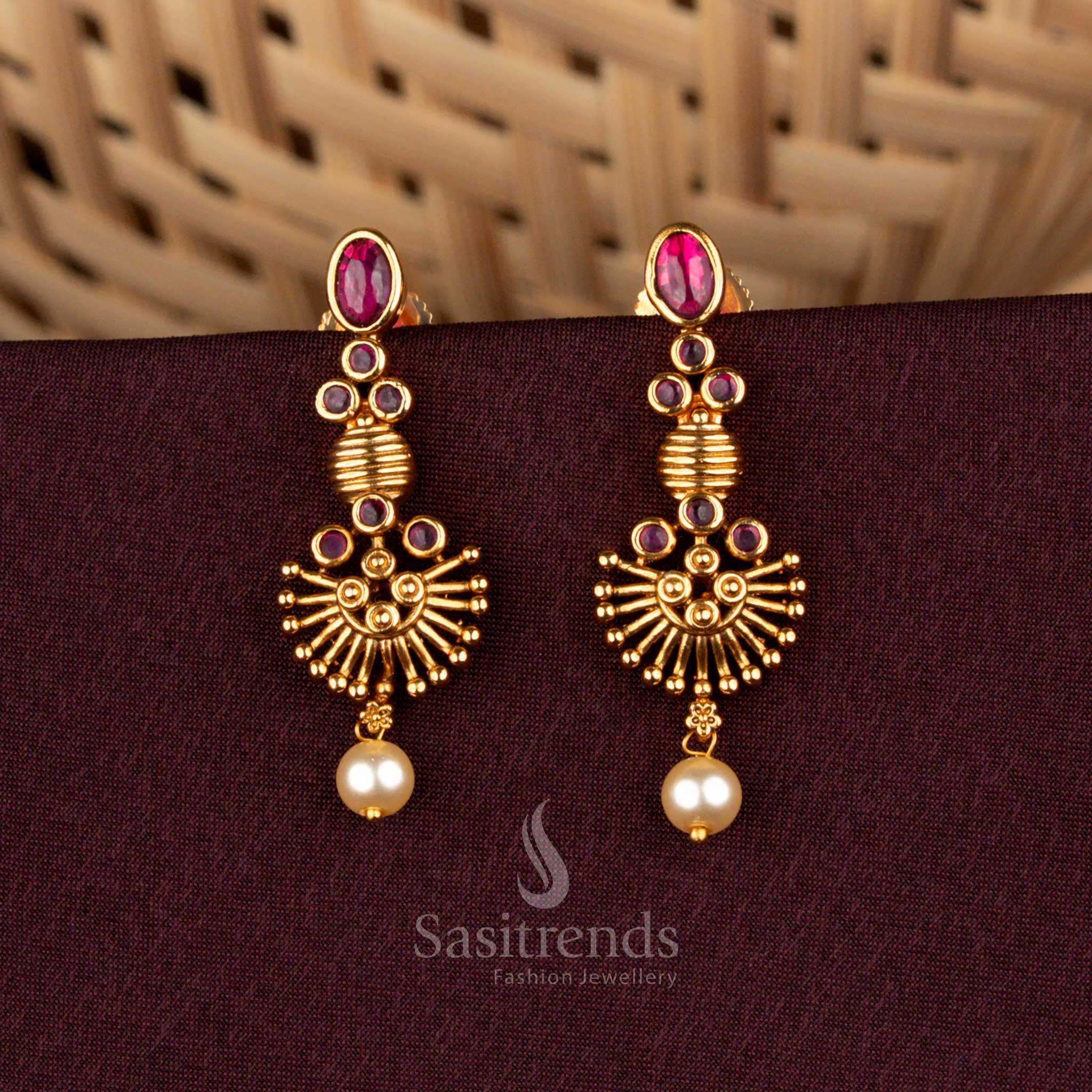 Grandiose ruby long temple earrings featuring divine sunburst artistry, radiant matte gold craftsmanship, ornate AD highlights, and aristocratic pearl refinement for bridal elegance – Sasitrends