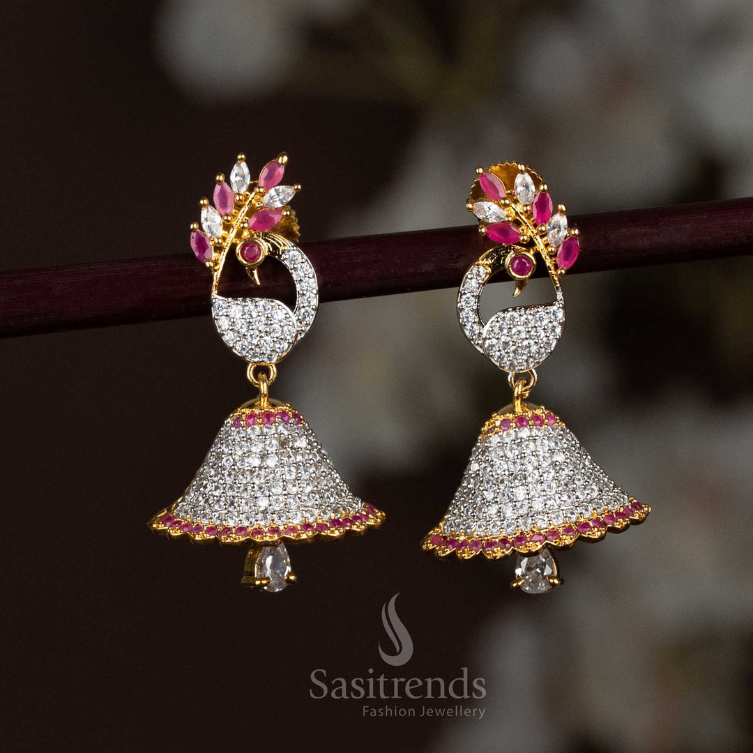 Regal white-ruby American Diamond Ganga Jhuma jhumka earrings adorned with a finely detailed peacock motif and gold plating, ideal for weddings, festivals, and saree looks – Sasitrends

