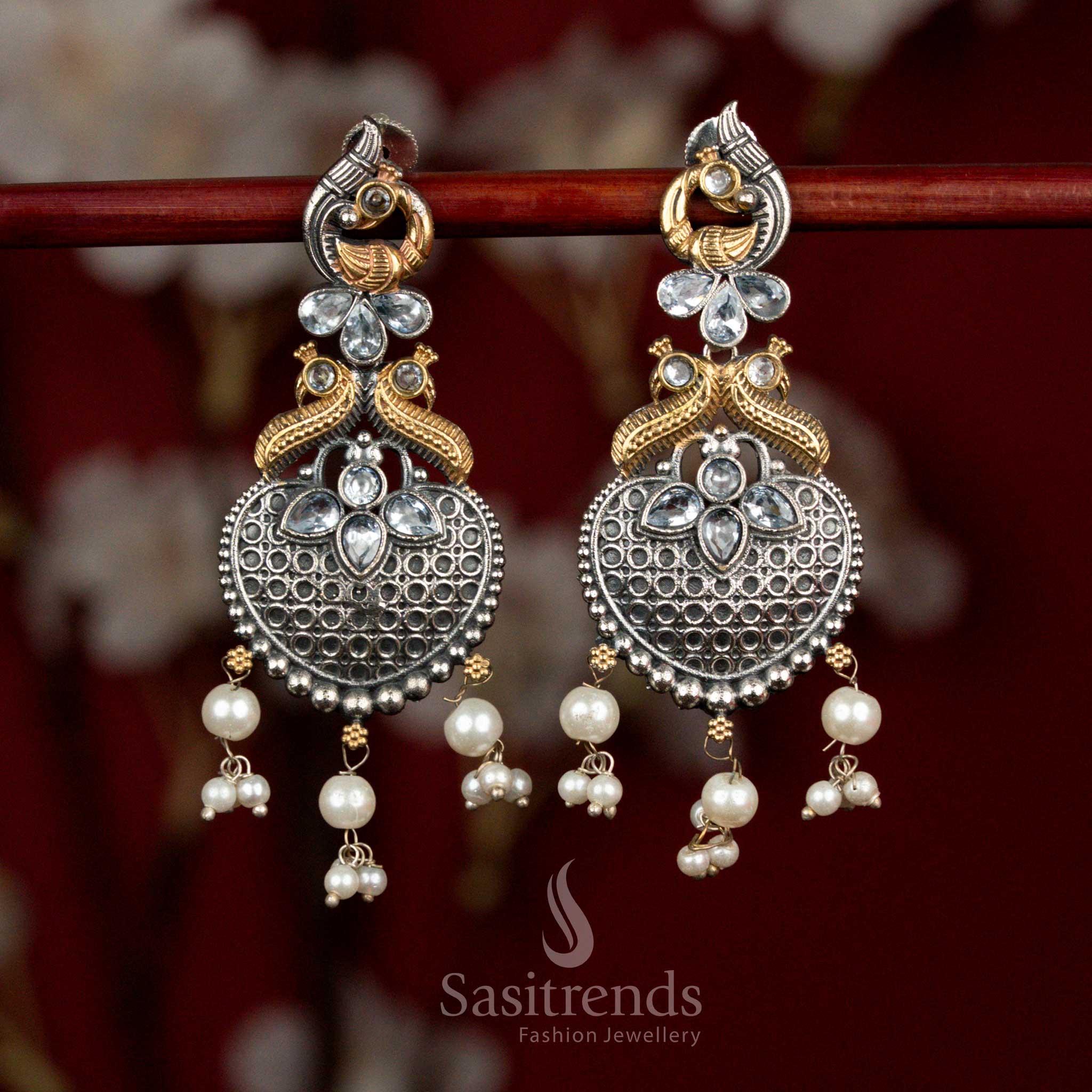 Antique oxidised silver earrings with luminous white Monalisa stones, intricate peacock heart motifs and soft pearl hangings for graceful cultural elegance - Sasitrends