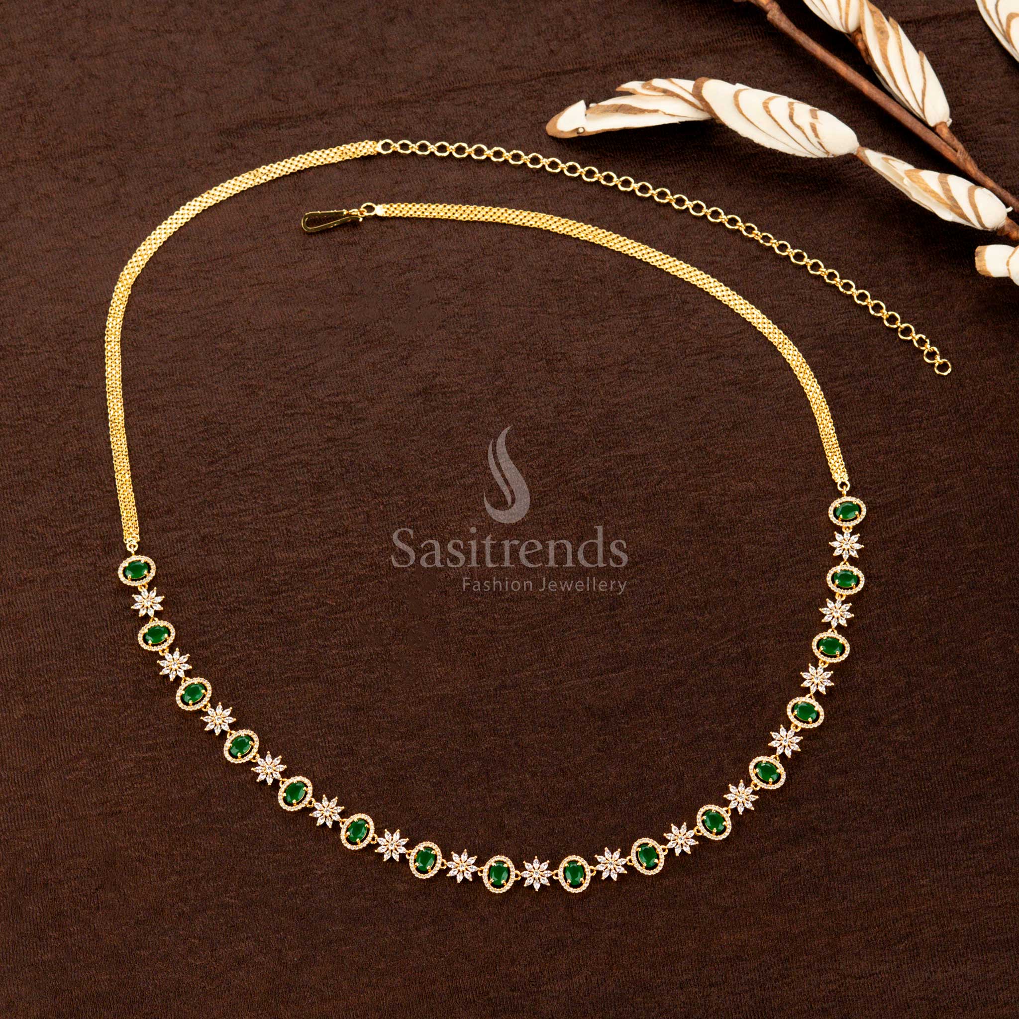 Emerald green gold-plated hip chain featuring sparkling American diamonds, a striking oval gemstone, and intricate floral detailing—an elegant choice for bridal wear - Sasitrends