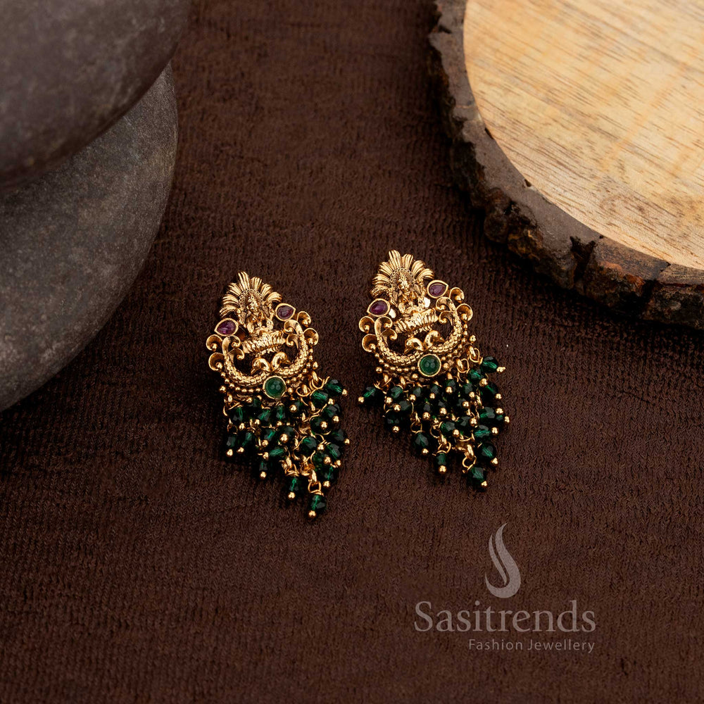Ornate matte gold temple earrings with Lakshmi and peacock detailing enhanced with ruby and green stones paired with green pearls and beads – Sasitrends