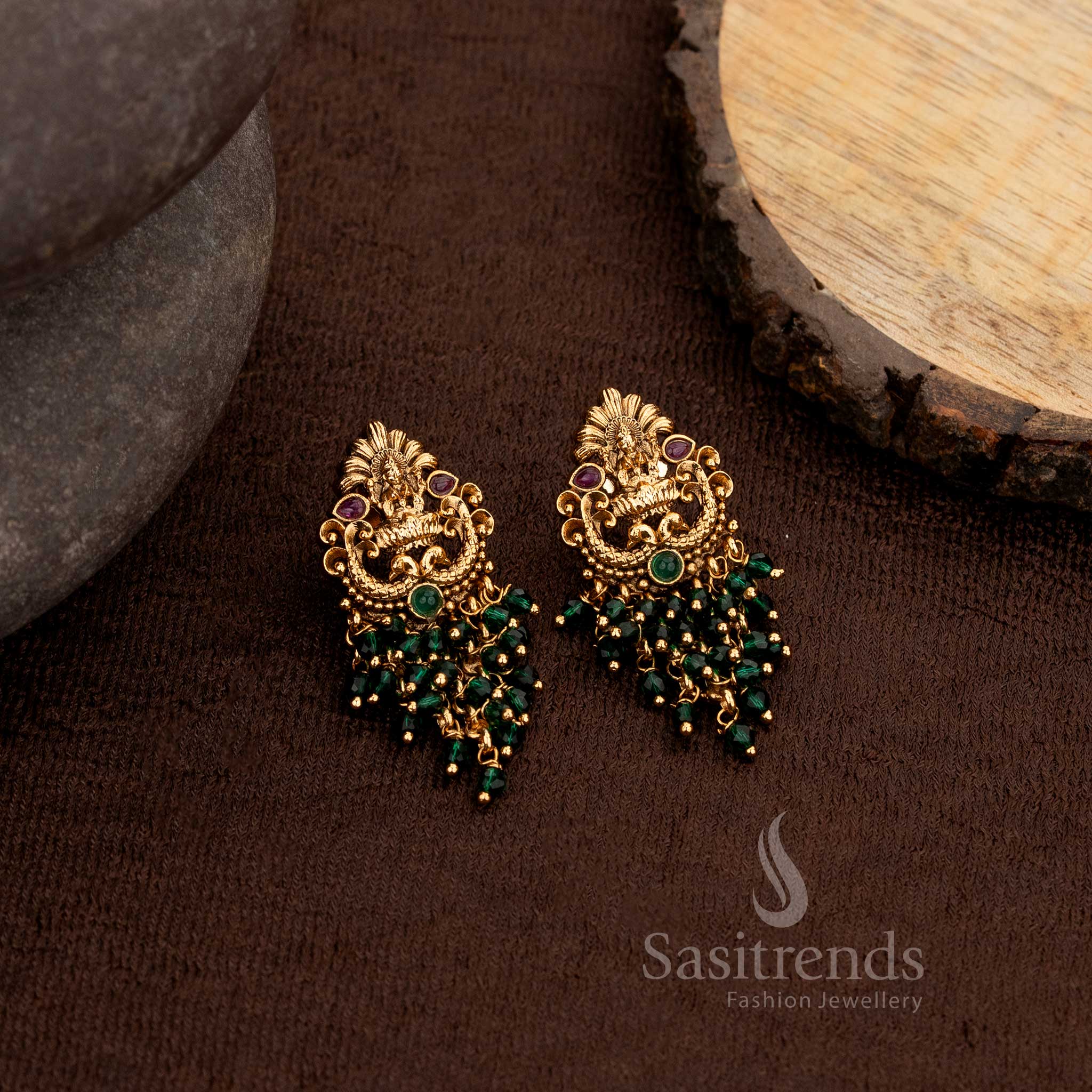 Ornate matte gold temple earrings with Lakshmi and peacock detailing enhanced with ruby and green stones paired with green pearls and beads – Sasitrends