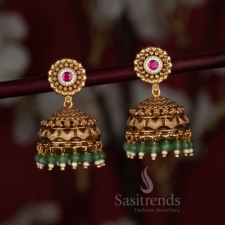 Divine temple-style matte gold plated jhumka earrings embellished with designer AD stones and lustrous decorative bead drops, ideal for weddings and traditional cultural occasions – Sasitrends