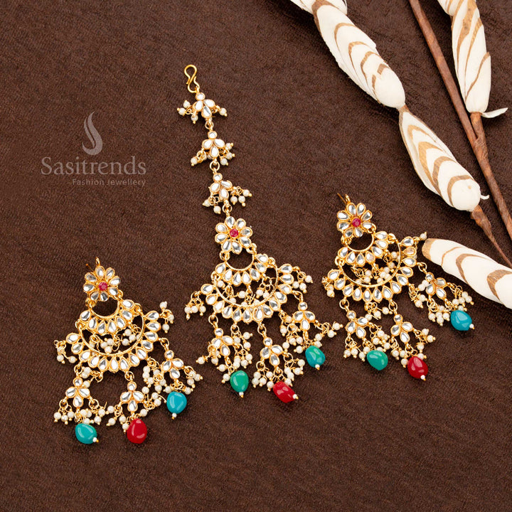 Traditional antique gold plated tikka and earrings set, showcasing deep ruby and rich green stones, an elegant crescent frame, and cascading pearl chains for a heritage bridal look - Sasitrends